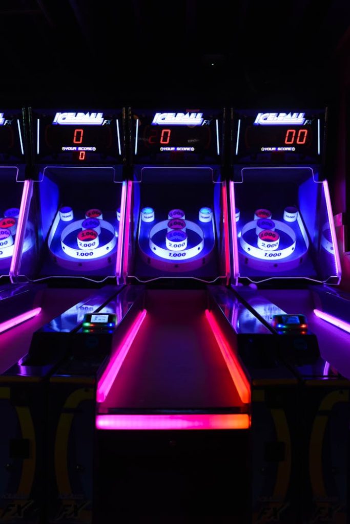 Vibrant and illuminated ski ball machines in a dark arcade setting.