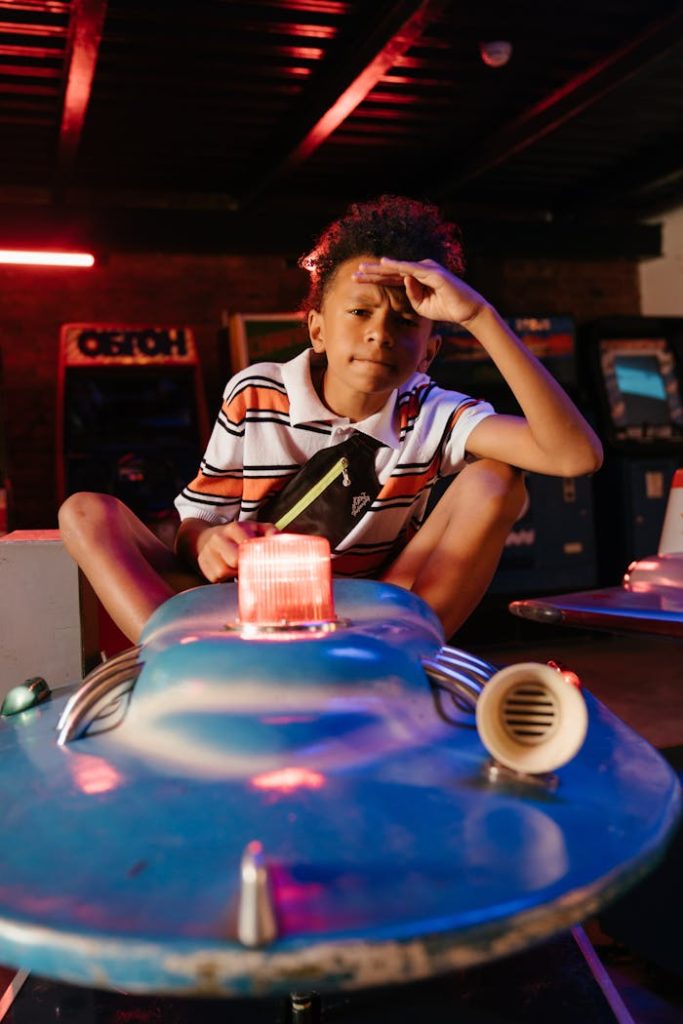 Teenage boy having fun on a spaceship ride in an indoor arcade setting.